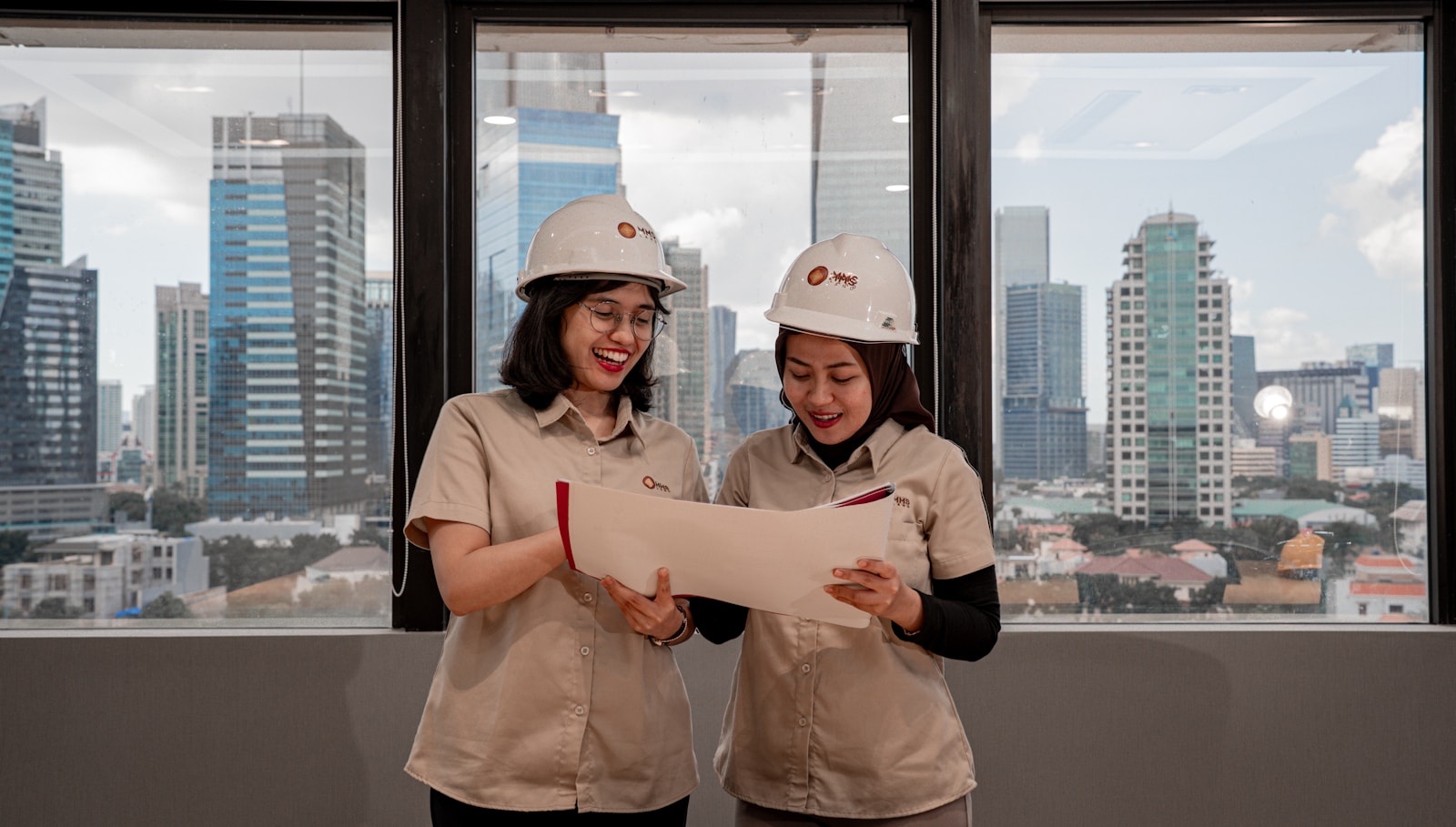 Professionals in hard hats reviewing MEP blueprints and plans